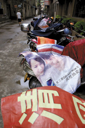 　7月11日，禅城升平路一粥店外，一排摩托车盖上了各式防雨的广告布。