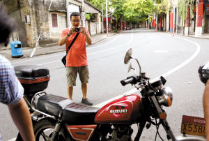 7月15日下午，一市民在办理自己摩托车报废手续时，给自己摩托车拍照留念。