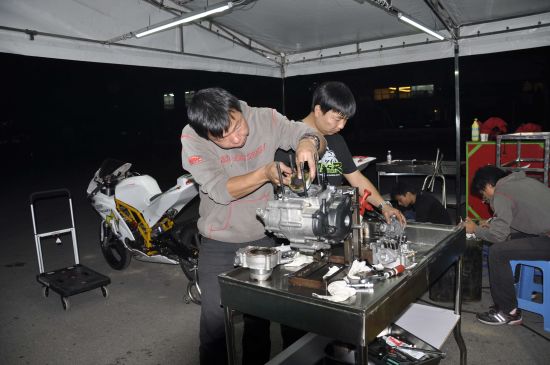 机械师在加班维修赛车发动机。