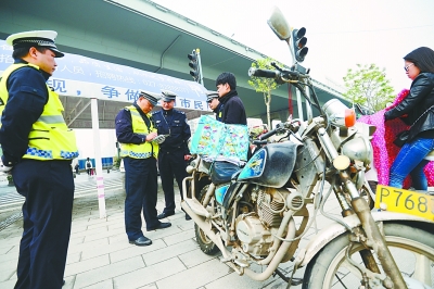 江岸交通大队民警对摩托车主进行处罚。