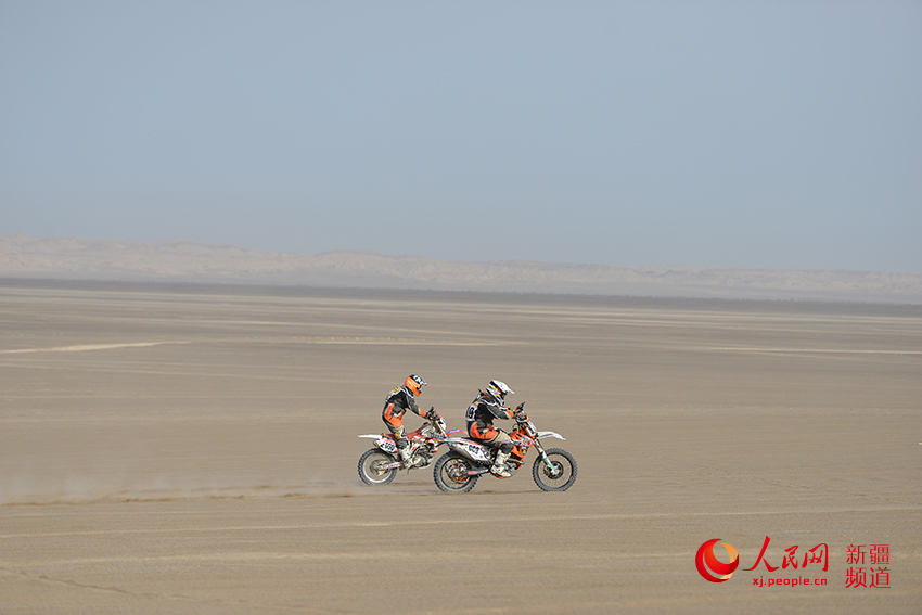 两名赛车手并驾齐驱，在沙漠赛道上演追逐大戏。徐蒙 摄